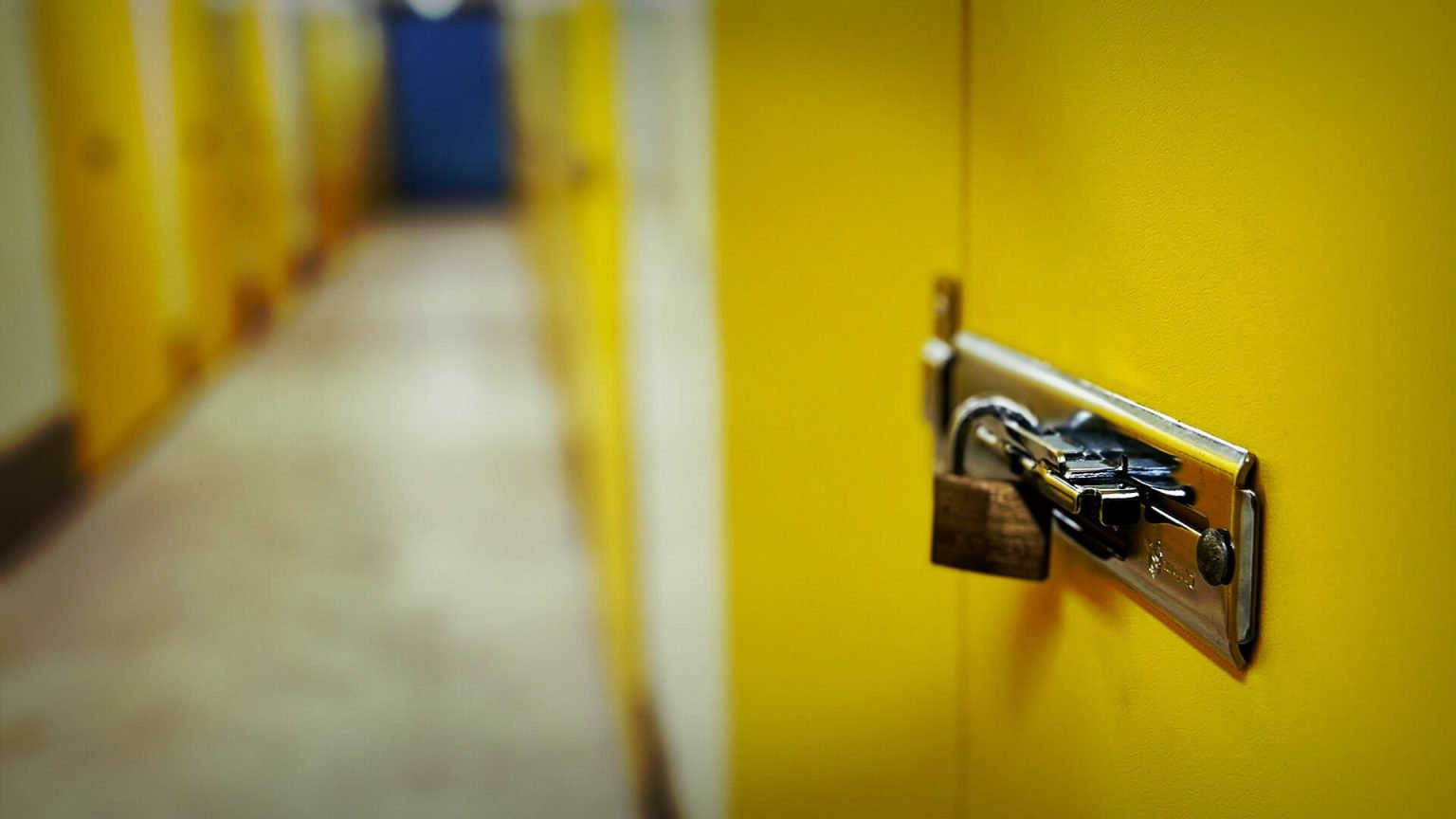 A secure padlock on a yellow door at manx storage units